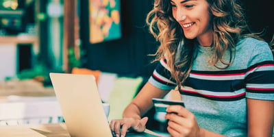 woman with credit card looking at computer